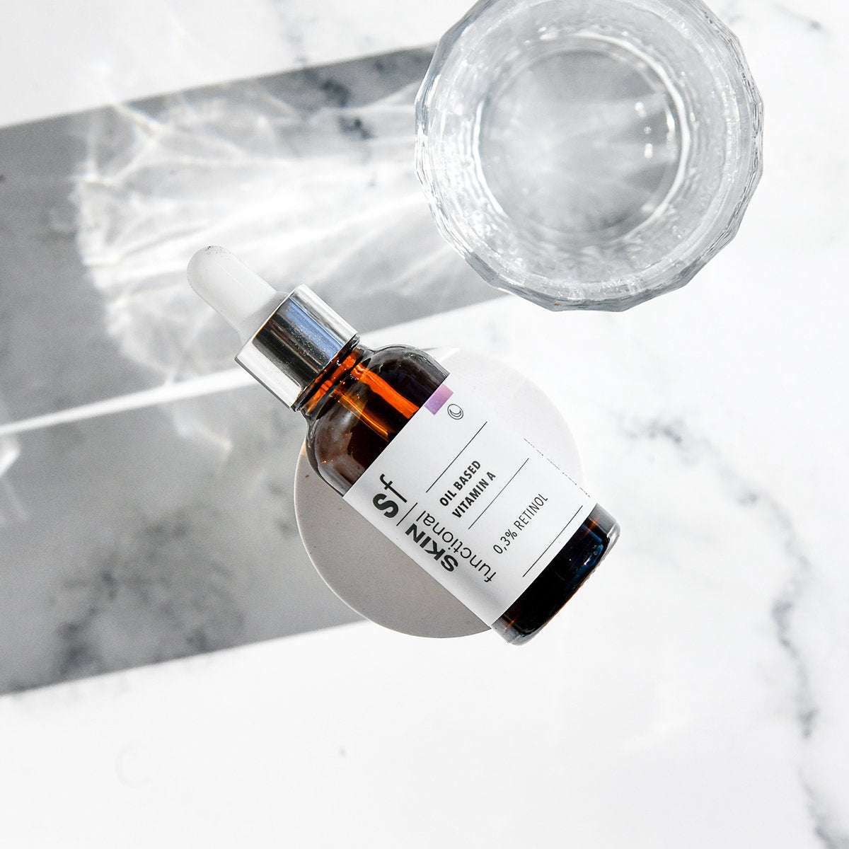 0,3% Retinol Oil Serum Skincare serum bottle with dropper on a marble surface