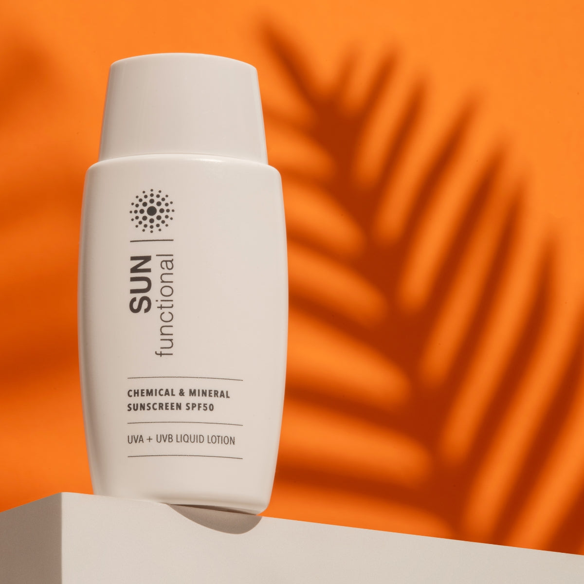 Sunscreen bottle labeled 'SUN functional' on an orange background with leaf shadows