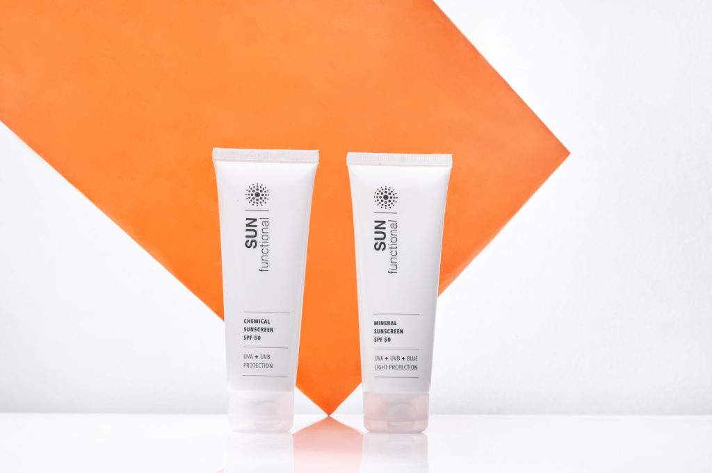 Two mineral  sunscreen bottles labeled 'SUN functional' on a white background with an orange geometric shape.